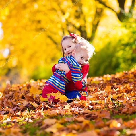 Kids playing in autumn park Stock Photo by ©FamVeldman 119853992