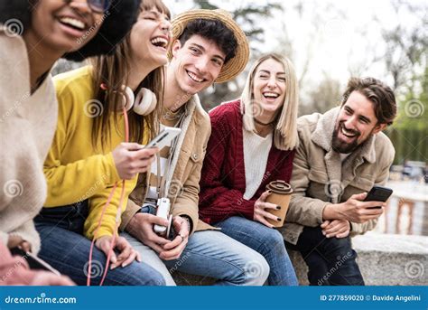 Group Of Young People Laughing Out Loud Sitting Outside Stock Photo