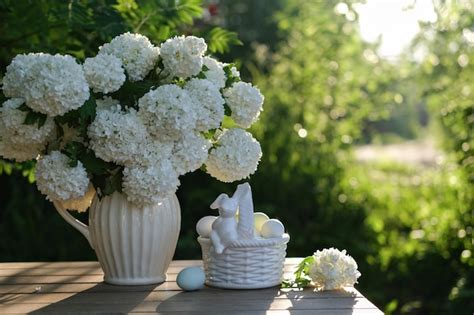 Premium Photo A Basket Of Eggs And A Vase Of White Flowers On A Table