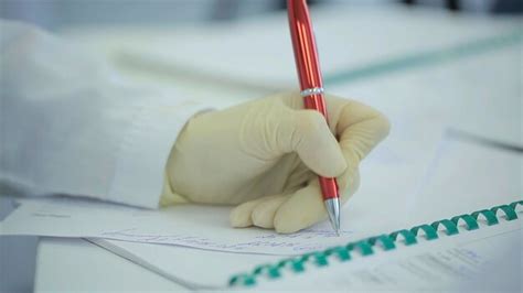 Premium Photo Midsection Of Doctor Writing On Paper At Clinic Close