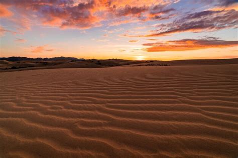 Puesta de sol sobre las dunas de arena en el desierto paisaje árido del