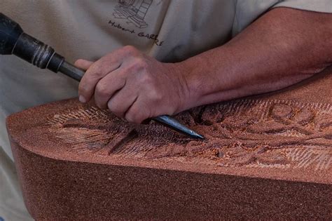 Mr Gardère en train de sculpter dans du grès rose Artisan de la Pierre