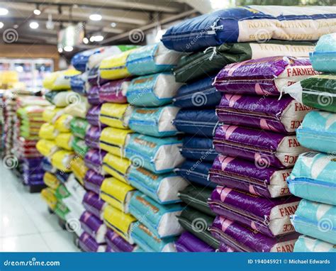 Sacks Of Various Rice Brands On Display At An Aisle In A Supermarket