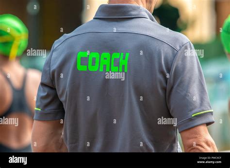 Back View Of Male Swimming Coaches Wearing Coach Shirt At An Outdoor