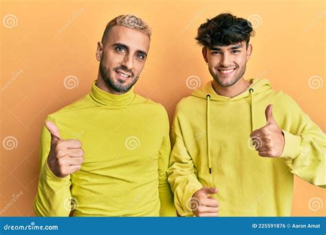 Homosexual Gay Couple Standing Together Wearing Yellow Clothes Success Sign Doing Positive