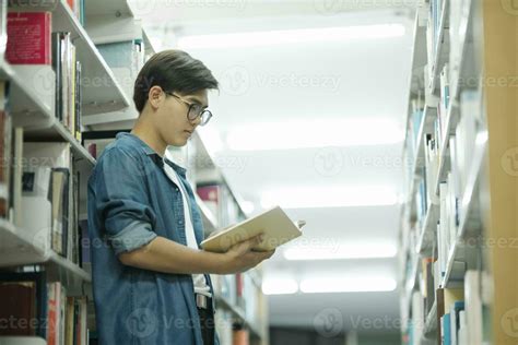 Student reading book at library. 24771248 Stock Photo at Vecteezy