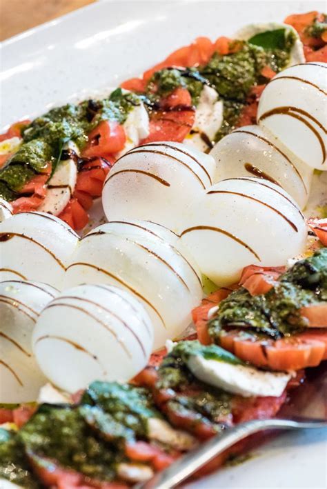 A White Plate Topped With Lots Of Food On Top Of A Wooden Table Next To