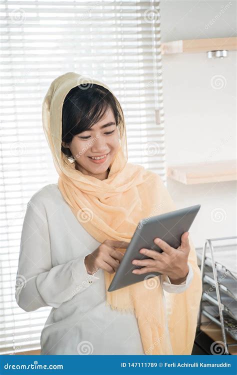 Hijab Que Lleva De La Mujer Musulm N Usando La Pc De La Tableta Imagen