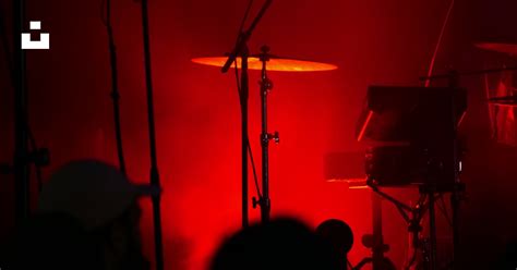 A band playing on a stage with red lighting photo – Free France Image on Unsplash