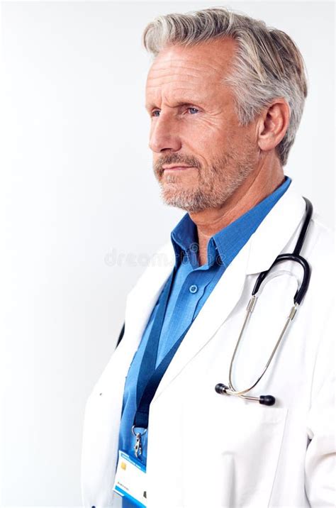 Profile Studio Shot Of Mature Male Doctor Wearing White Coat And