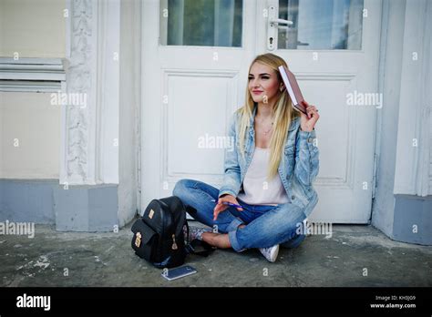 Fille blonde l usure des jeans avec sac à dos posé contre l ancienne porte avec journal et