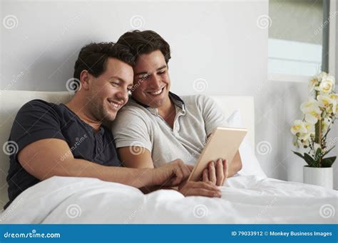 Le Coppie Gay Maschii Si Rilassano Insieme A Letto Facendo Uso Della Compressa Digitale