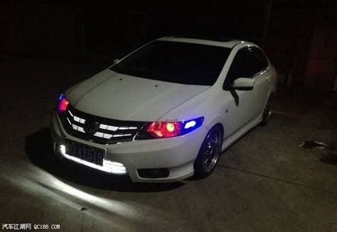 A White Car Parked In The Dark With Its Lights On