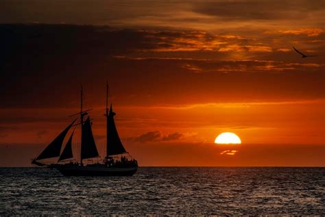 Silhueta de um barco à vela em plena vela ao pôr do sol Foto Premium