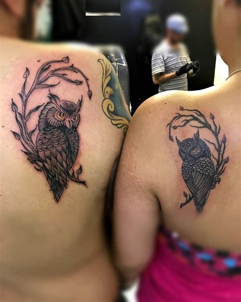 Two Women With Tattoos On Their Backs Showing Off Their Back Side