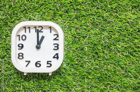 closeup white clock  decorate   oclock  green artificial grass