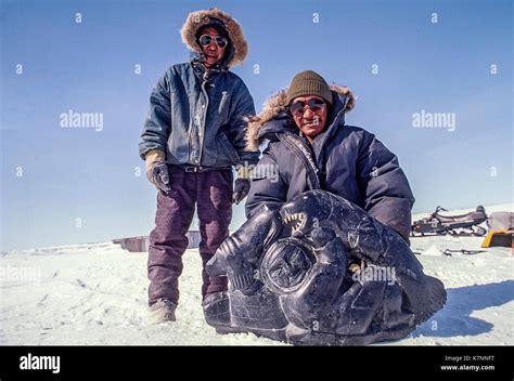 Inuit elders dressed in modern clothing show off one of their stone Stock Photo: 159673787 - Alamy