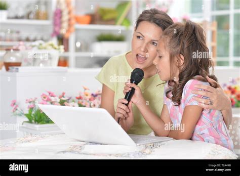 Mother And Daughter Singing Karaoke With Microphone Together Stock