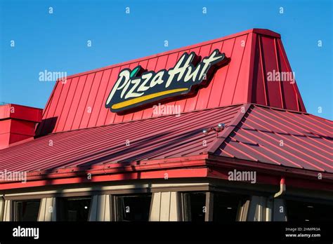 An exterior view of a Pizza Hut restaurant sign and logo on a roof ...