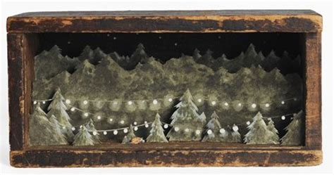 An Old Wooden Box With Christmas Lights And Trees In The Woods On It S