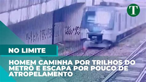 Homem caminha por trilhos do metrô e escapa por muito pouco de