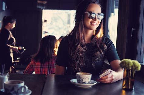 Premium Photo Portrait Of Smiling Brunette Woman In Sunglasses Drinks Morning Coffee In A Cafe