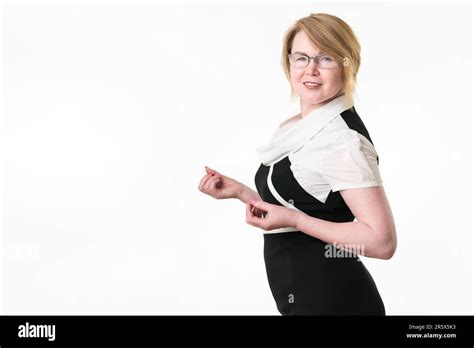 Portrait Of Blonde Woman In Glasses Dressed In Black And White Dress Looking At Camera