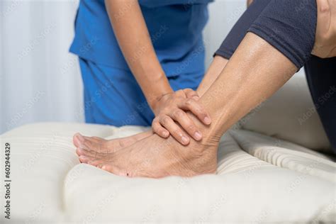 Female Asian Physiotherapist Worker Giving Leg Massage To Senior Woman Closeup Rehabilitation