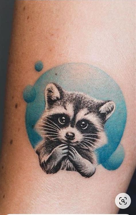 A Small Raccoon Tattoo On The Arm