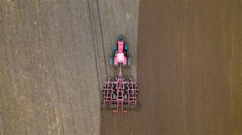 Un Tracteur Avec Une Charrue De Remorque Laboure Le Champ D Un