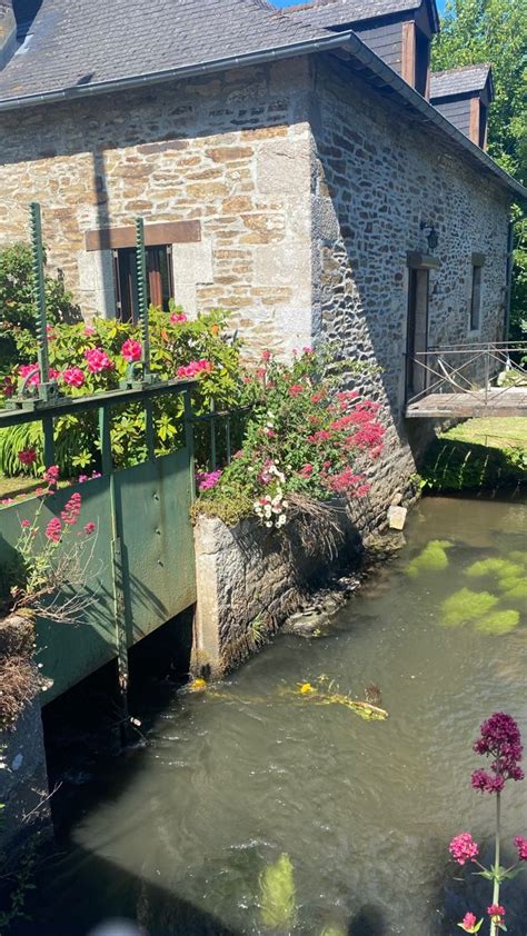 An Old Stone Building With Flowers Growing Out Of It S Windows And