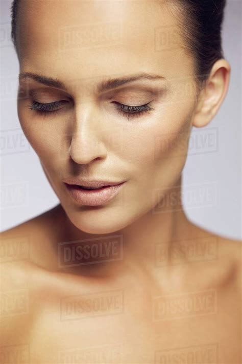 Closeup Portrait Of Fresh And Beautiful Young Lady Looking Down Against