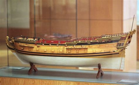 a model boat is on display in a glass case with wood trimming around it