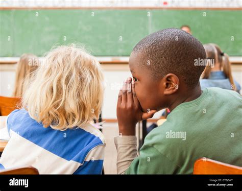 Boys Whispering During Lesson Stock Photo Alamy