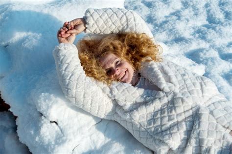 Beautiful Mature Redhead Woman In Her Fifties With Red Curly Hair Lying In The Winter Snow With