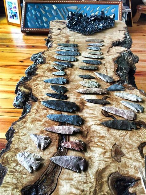 A Long Table Covered In Lots Of Knives On Top Of A Hard Wood Floor Next