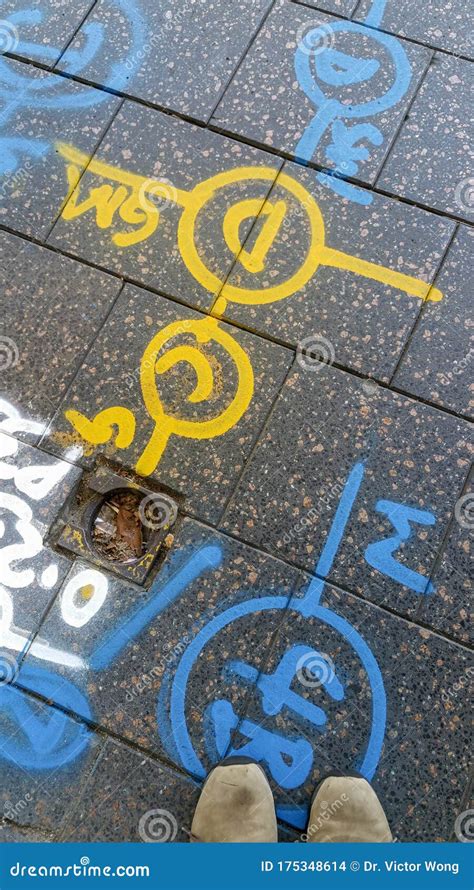 Alphanumeric And Symbol Spray Paint Markings On A Pedestrian Footpath