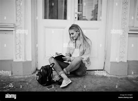 Fille blonde l usure des jeans avec sac à dos posé contre l ancienne porte avec journal et