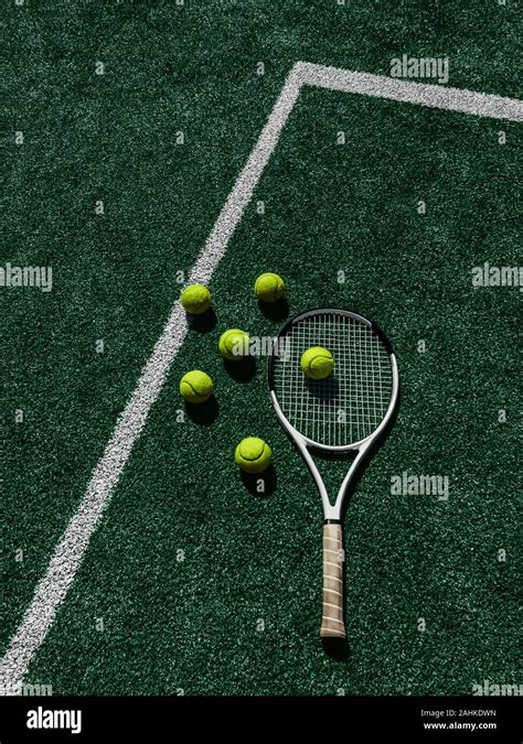 Tennis Court Top View Six Tennis Balls And Racket On The Green Grass