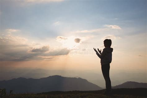 Silhouette De Una Mujer Con Las Manos Levantadas En La Puesta Del Sol