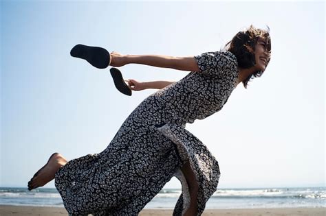 Foto completa mulher japonesa correndo na praia Foto Grátis