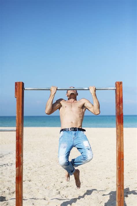 A Male Athlete With A Naked Torso Is Training On A Horizontal Bar Stock Image Image Of