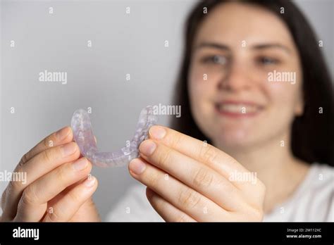 A Woman Holds Dental Mouthguard Splint For The Treatment Of