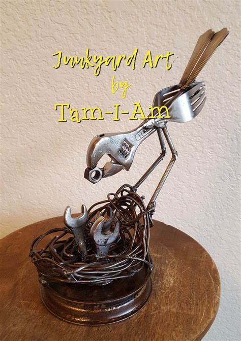 A Metal Bird Sculpture On Top Of A Wooden Table With Forks And Spoons In It