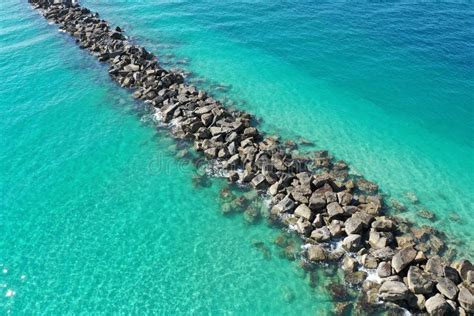 Aerial View Of Rock Jetty Surrounded By Clear Shallow Water Of Miami