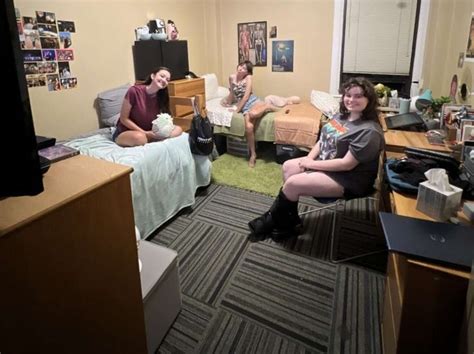 three people sitting in a dorm room together