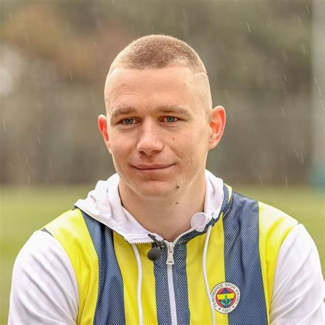 A Man With A Bald Head Wearing A Yellow And Blue Vest