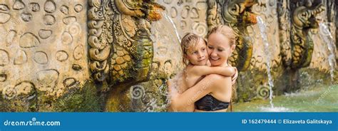 Mom And Son Travelers In Hot Springs Banjar Thermal Water Is Released From The Mouth Of Statues