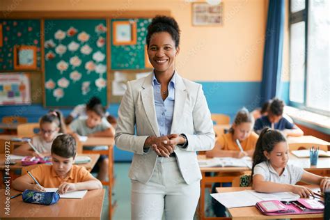 Happy African American elementary school teacher with her students in ...