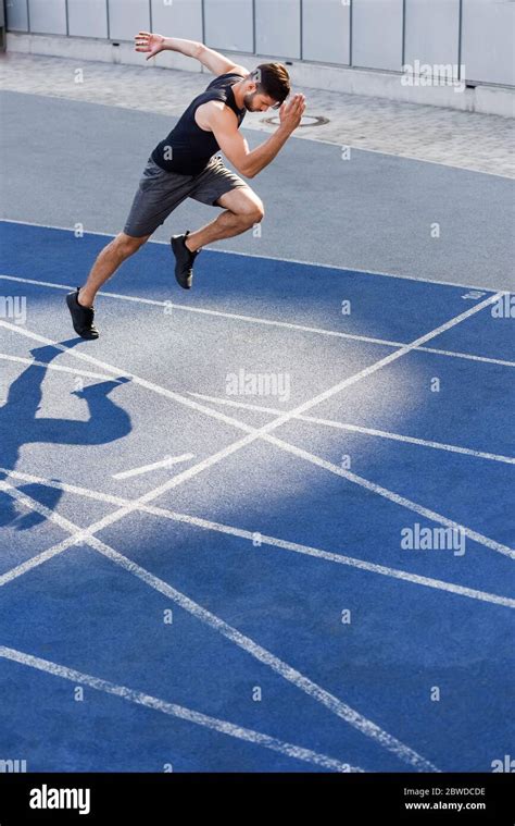 Handsome Runner Exercising On Running Track At Stadium Stock Photo Alamy